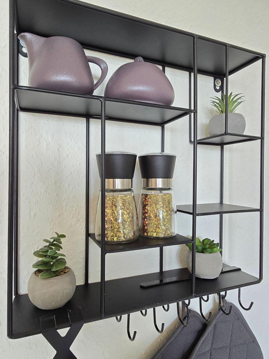 Wandregal mit Kräutertöpfen, Pflanzen und Haken für Jacken.