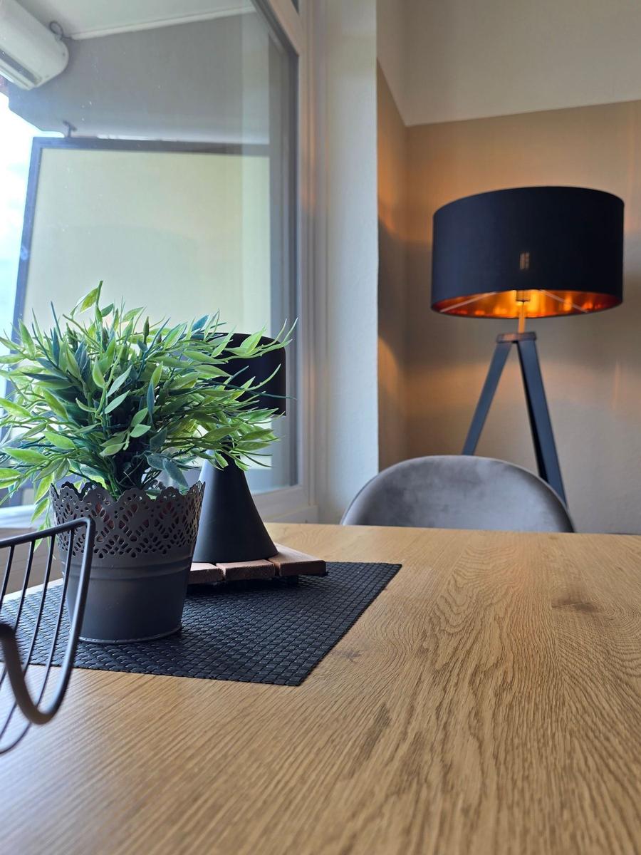 Holztisch mit Pflanze und Stehlampe im Raum