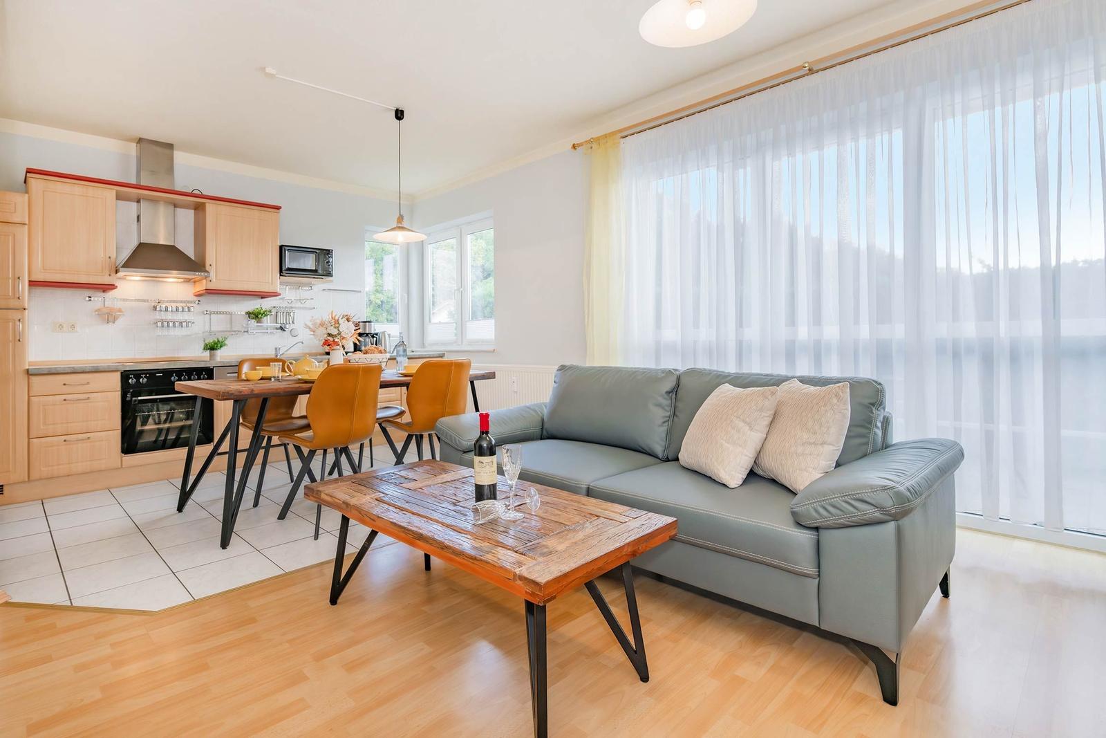 Wohnküche mit Sofa, Esstisch und Kücheneinrichtung.