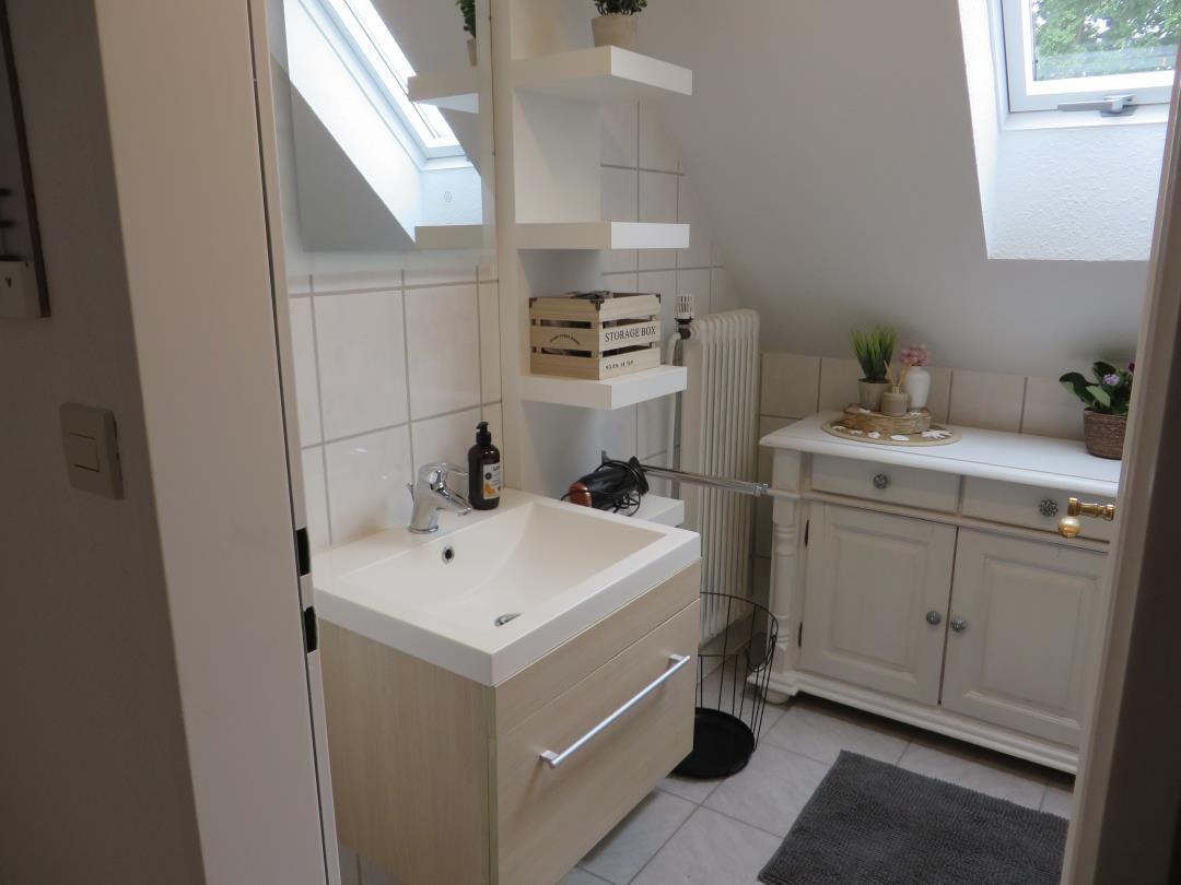 Badezimmer mit Waschbecken, Spiegelschrank und Fenster