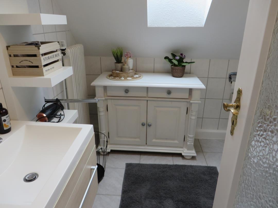 Badezimmer mit Waschbecken, Schrank und Dachfenster