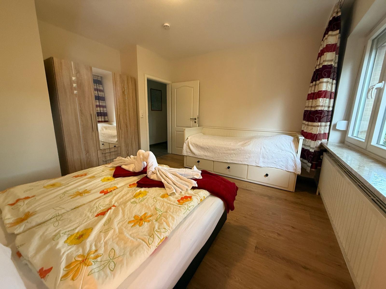 Doppelbett und Einzelbett; Nachttisch und Tischlampe, Kleiderschrank