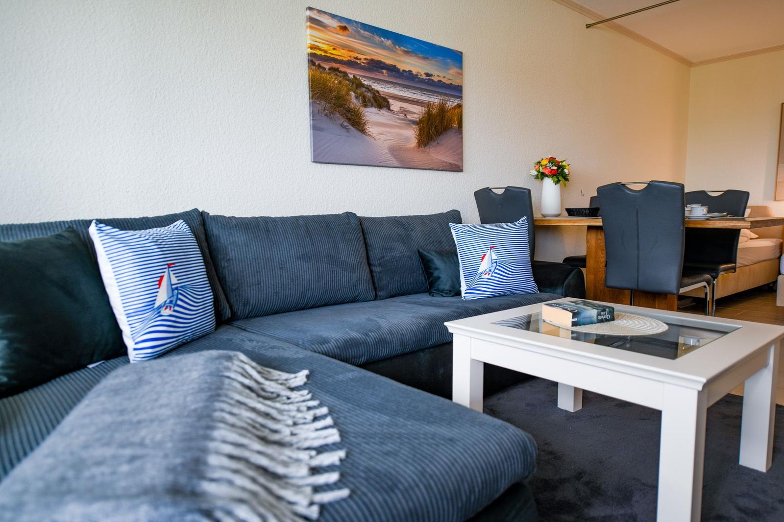 Wohnzimmer mit Sofa, Couchtisch und Wandbild