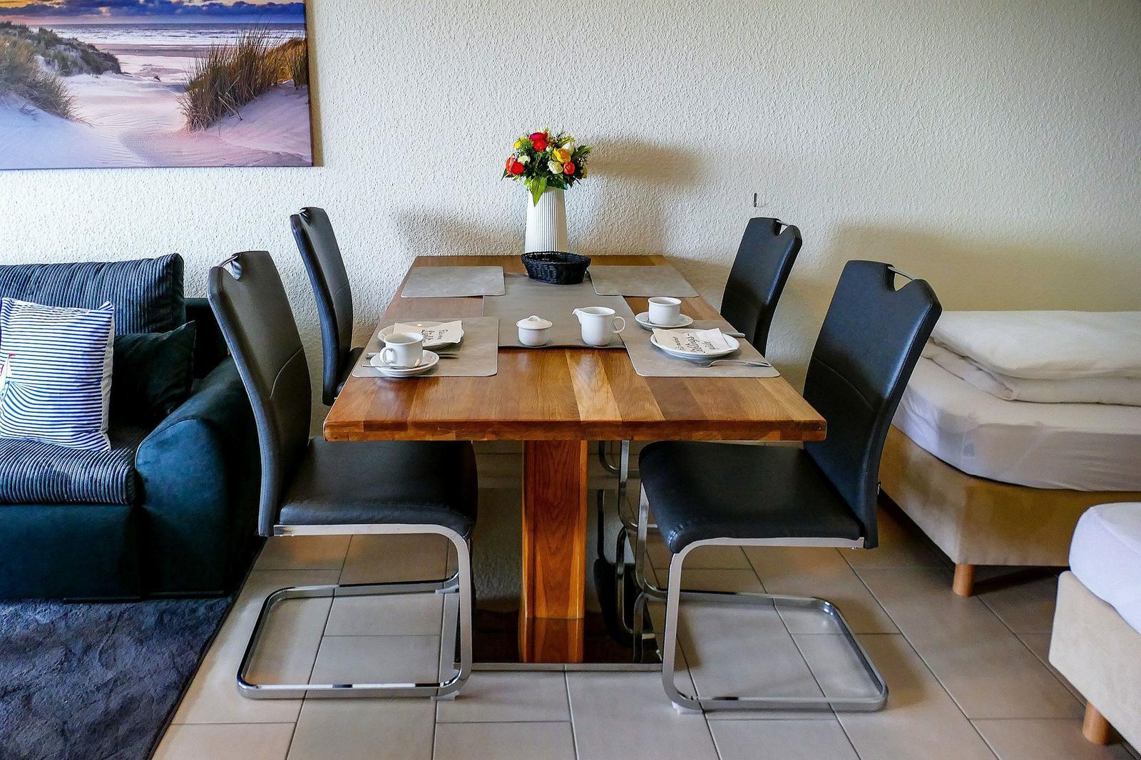 Esstisch mit Stühlen, Sofa und Bett im Raum
