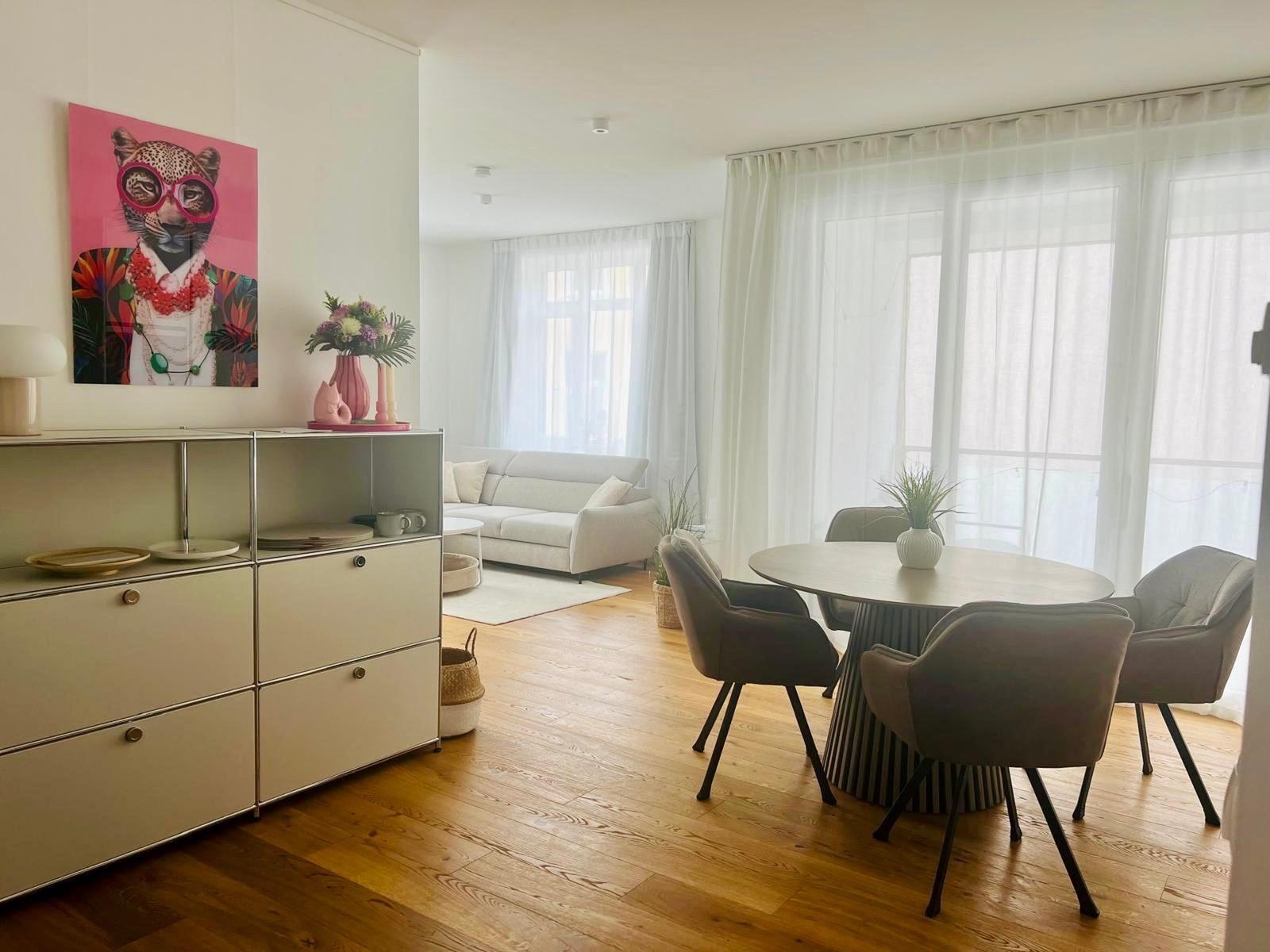 Wohn- und Essbereich mit Esstisch, Sofa und Wandbild