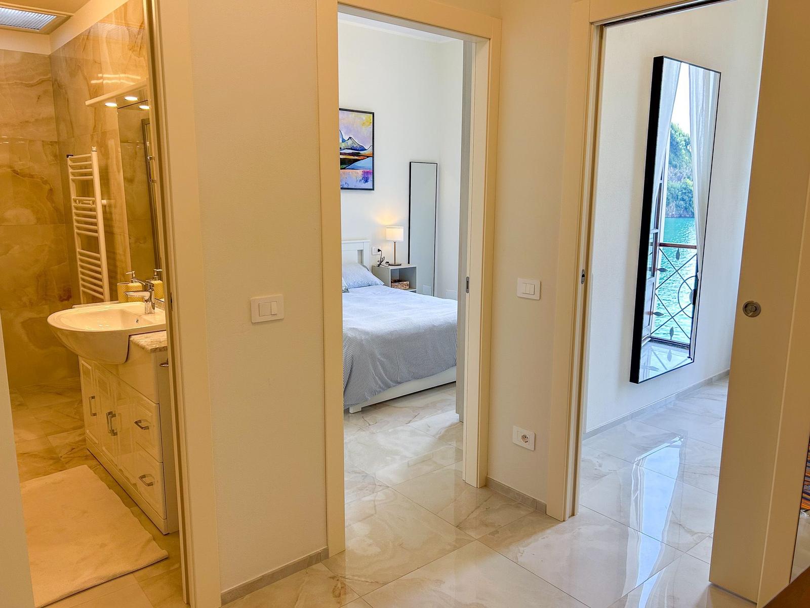 Bathroom, bedroom and balcony with water view.