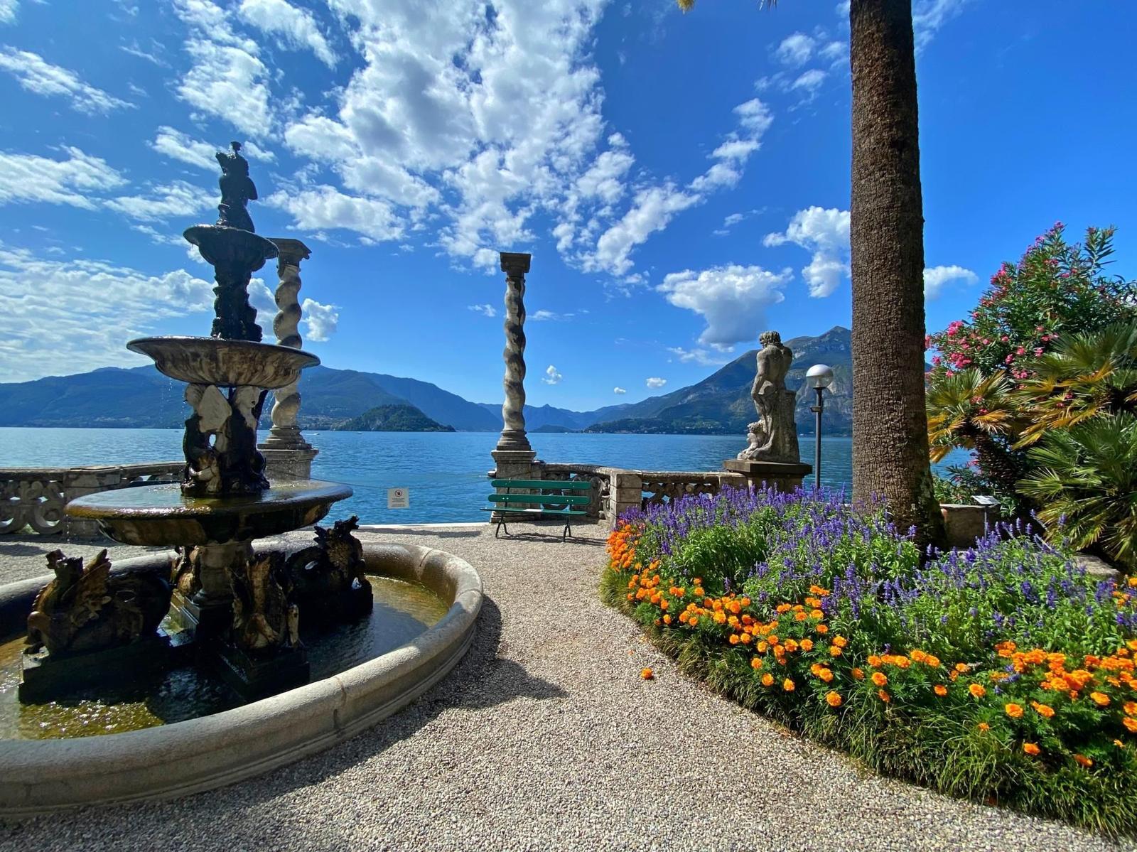 Garden with fountain, flower beds, and view of the lake