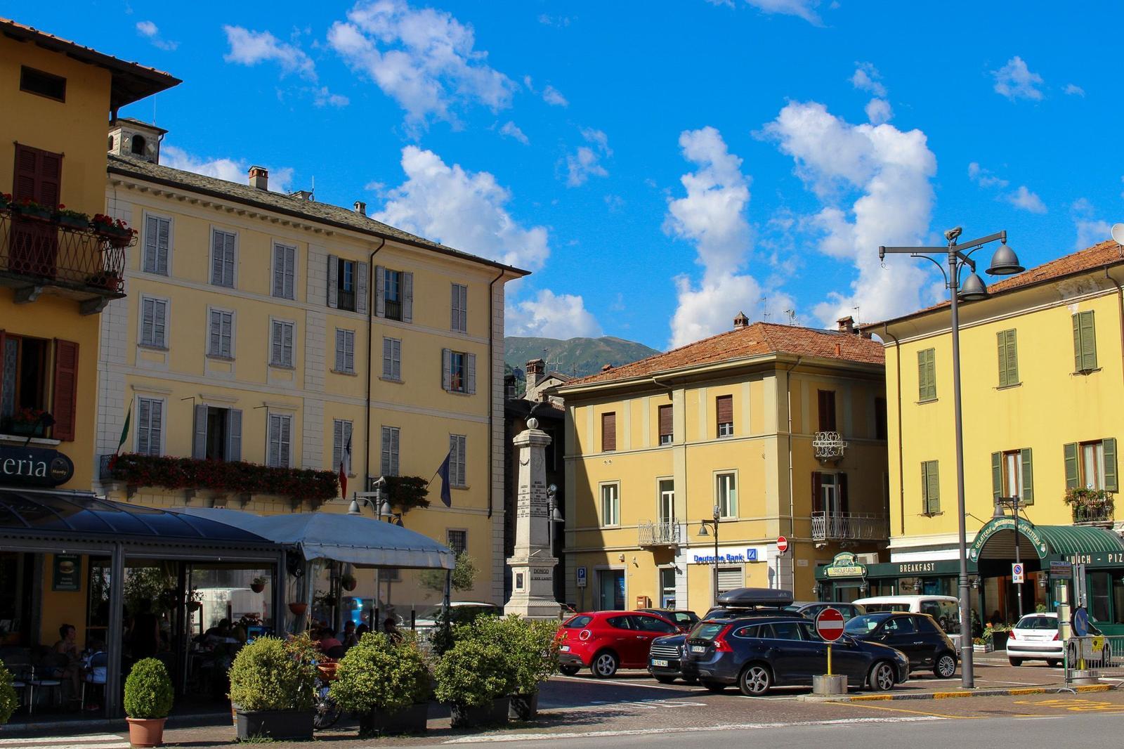 Town center with yellow buildings, streets, and parking spots under blue sky.