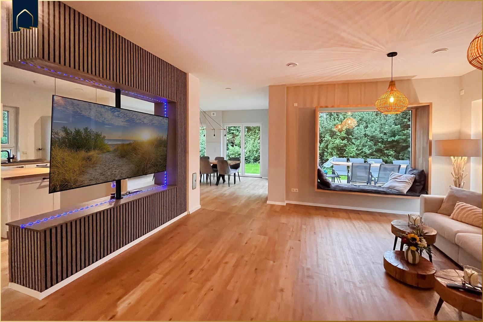 Wohnzimmer mit TV, Sofa und Blick auf Garten