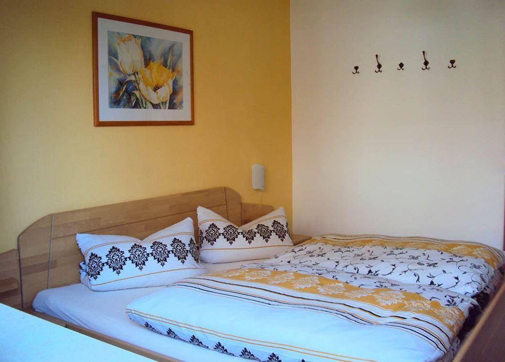 Schlafzimmer mit Bett, Wandbild und Haken