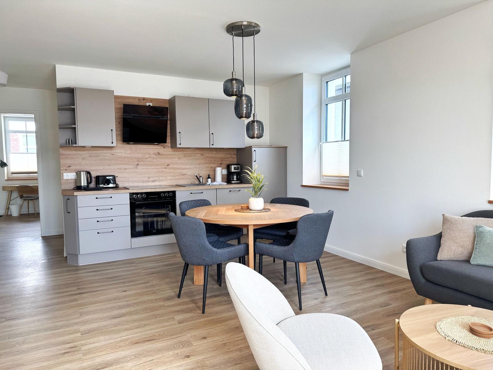 Küche mit Esstisch, Wohnbereich und Sofa