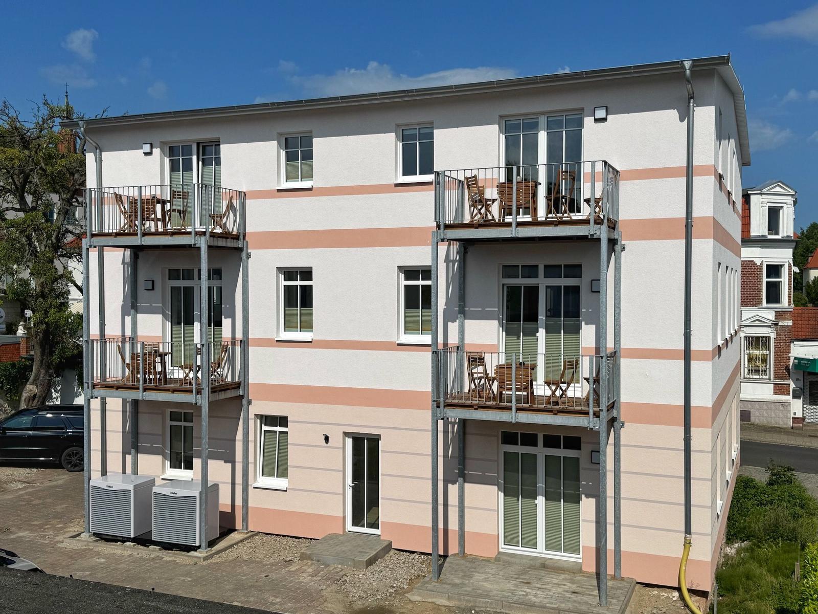 Ferienwohnung mit Balkonen und Terrassen. Modernes Gebäude mit Fenstern und Türen.