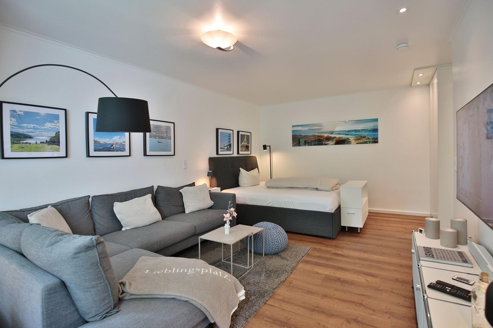 Schlafzimmer mit Sofa, Bett und Wandbildern