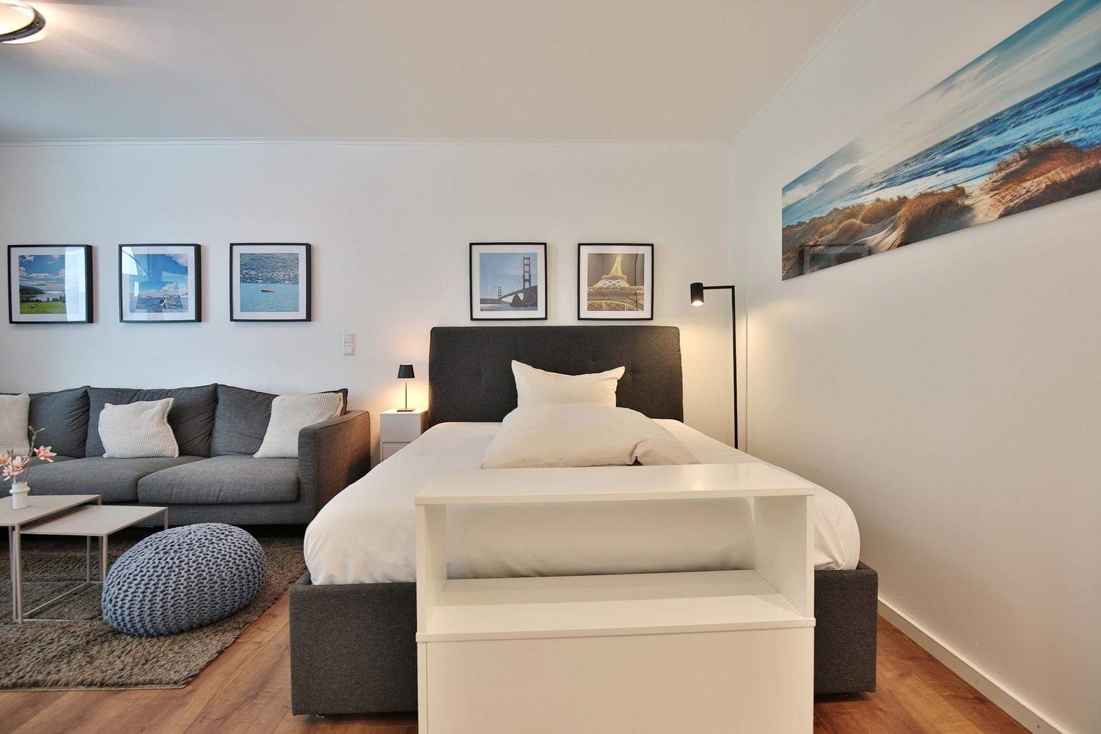 Schlafzimmer mit Bett, Sofa und Wandbildern