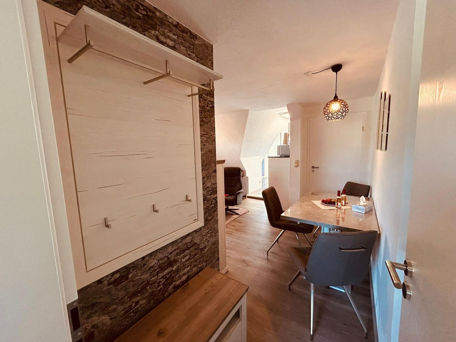 Essbereich mit Tisch und Stühlen, Schlafzimmer mit Schiebetür und Holzboden