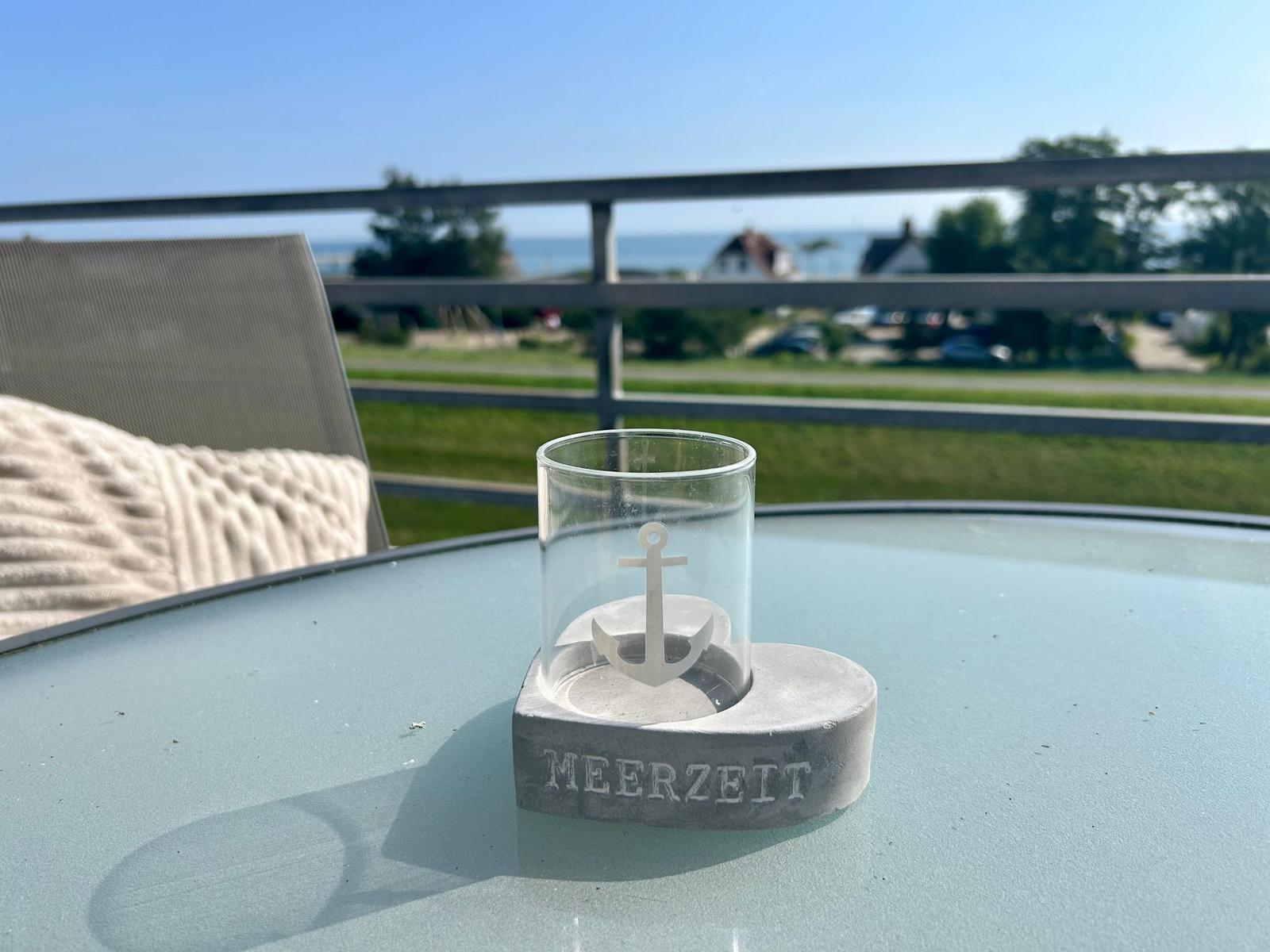 Auf der Terrasse steht ein Glas mit Anker auf einem Sockel mit der Aufschrift MEERZEIT.