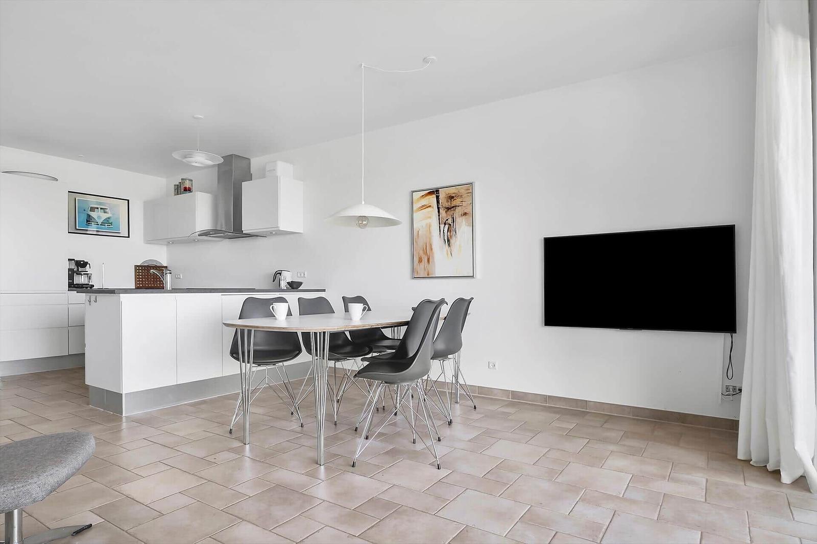 Küche mit Essbereich und Fernseher an der Wand