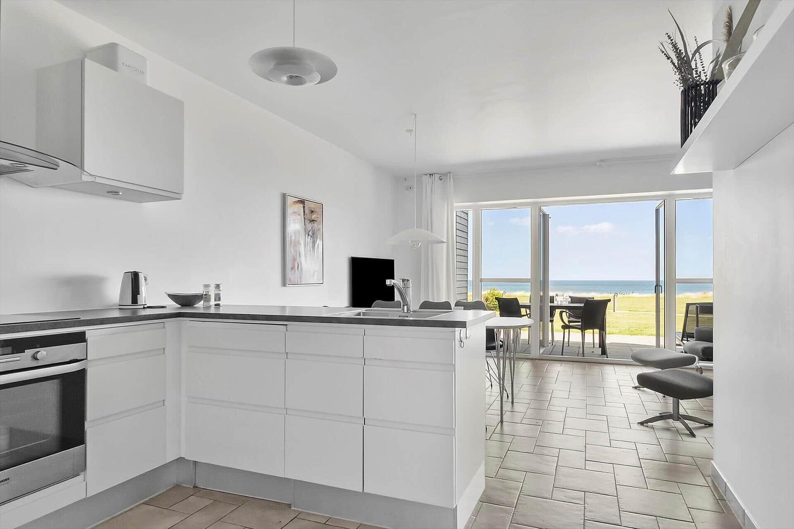 Moderne Küche mit Blick auf den Strand und Terrasse.