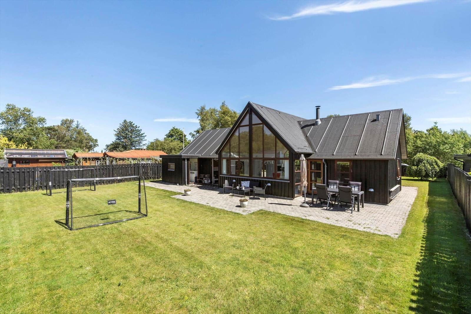 Moderne Villa mit großem Garten, Terrasse und Fußballtor.