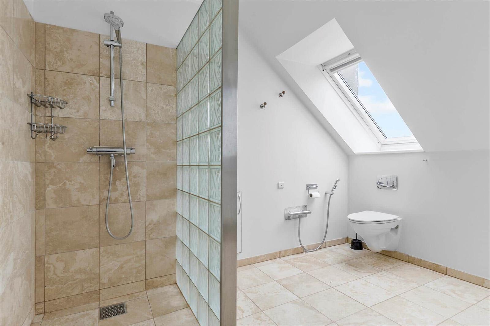 Bad mit Dusche und WC unter Dachschräge mit Dachfenster.