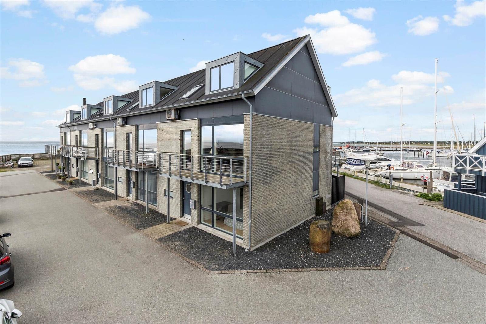 Moderne Häuser mit Balkonen am Hafen mit Booten.