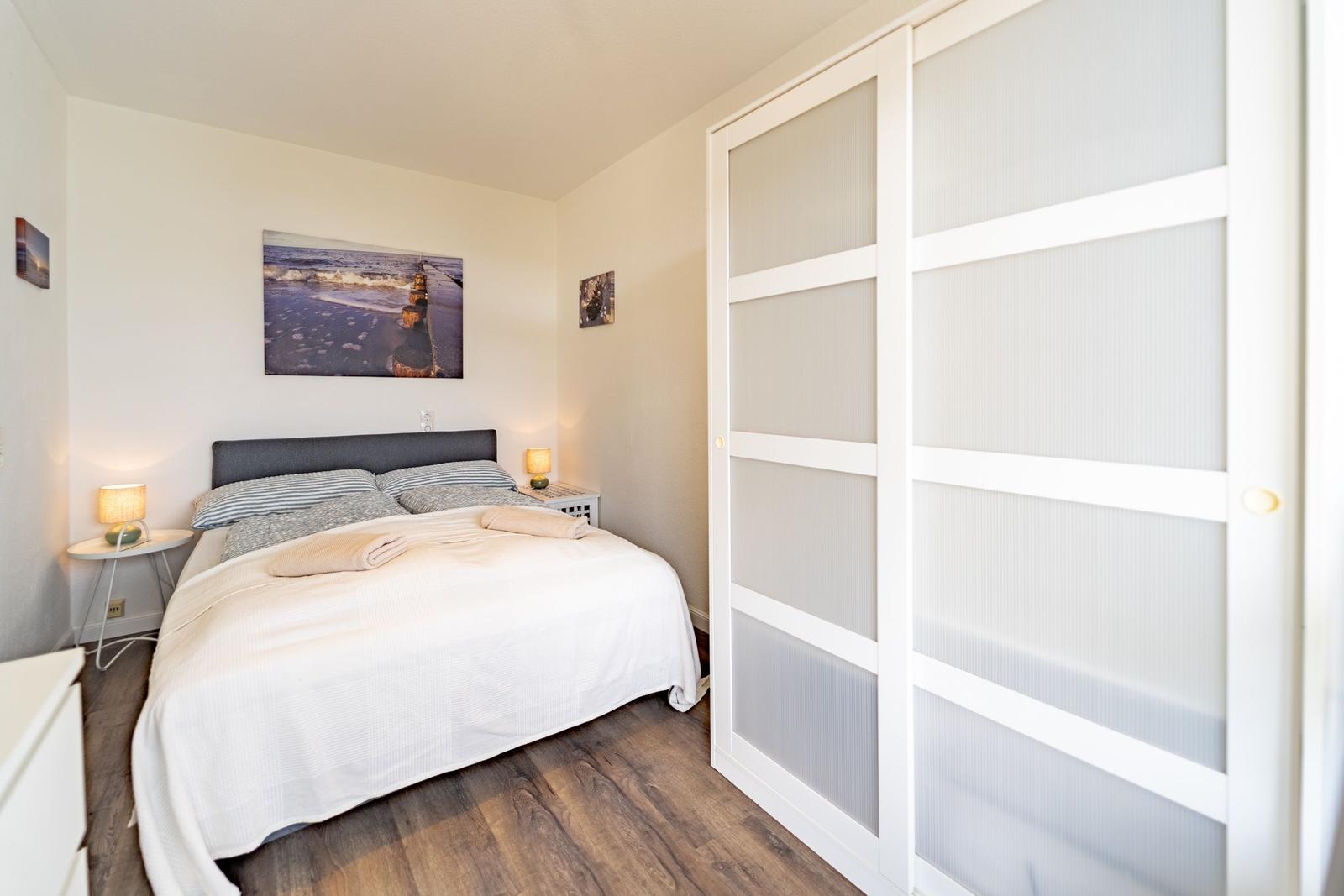 Schlafzimmer mit Doppelbett, Schrank und Wandbild