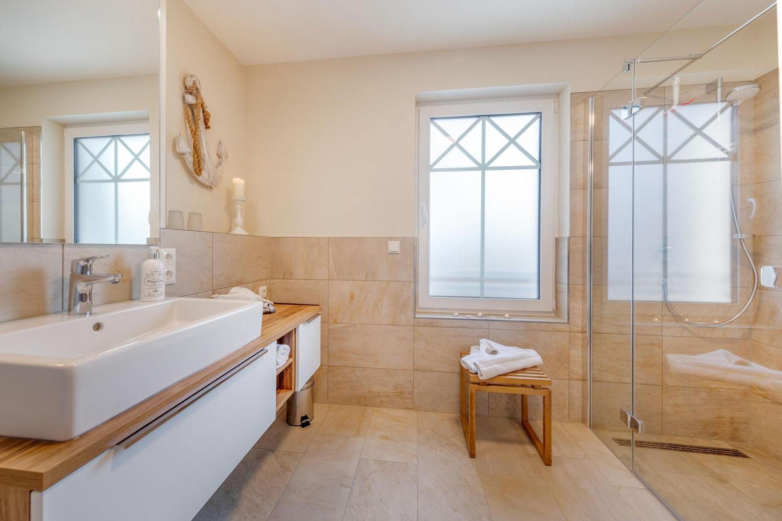 Badezimmer mit Dusche, Waschbecken und Fenster mit Blick.