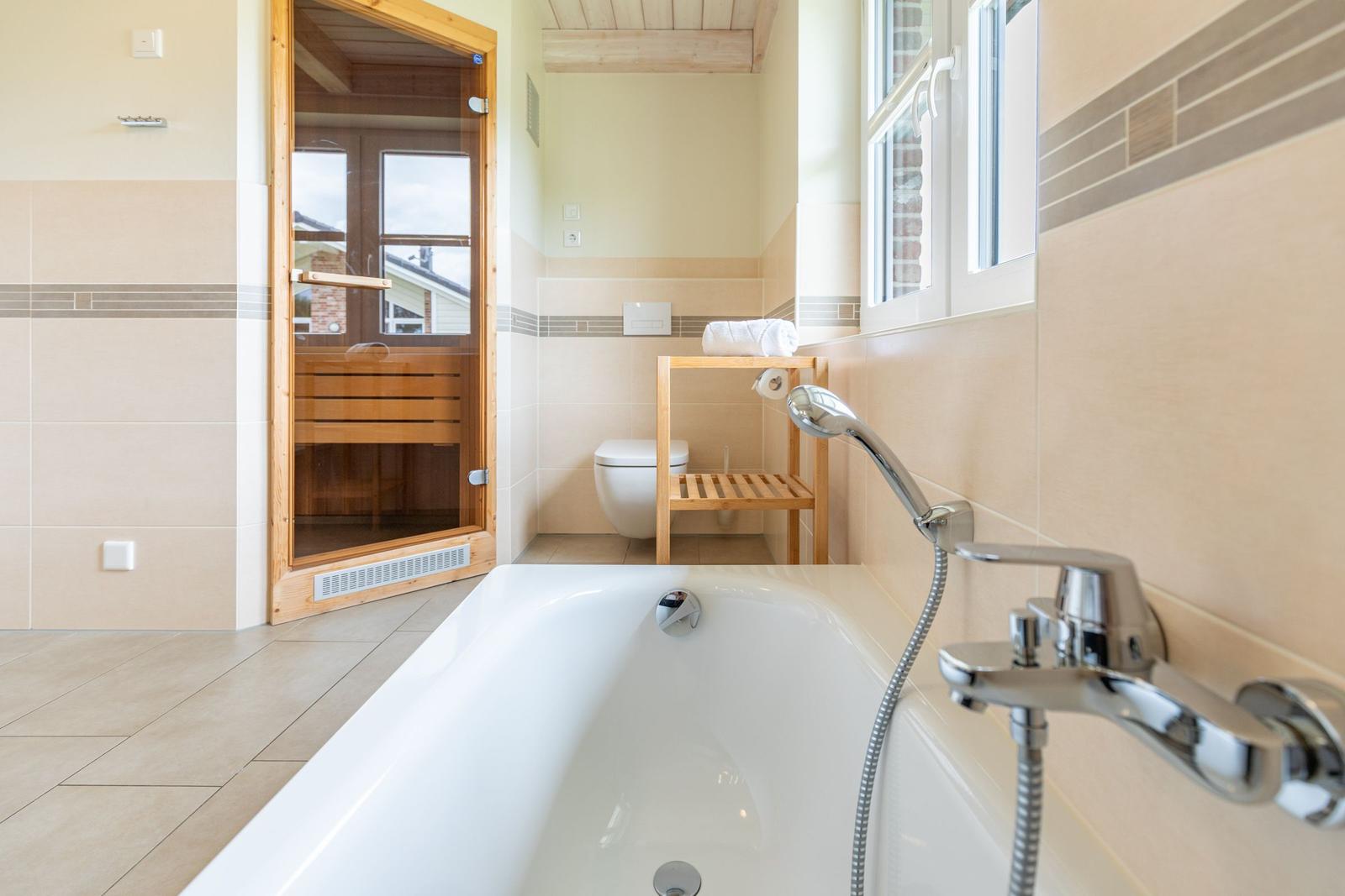Bad mit Badewanne, Dusche und Sauna.