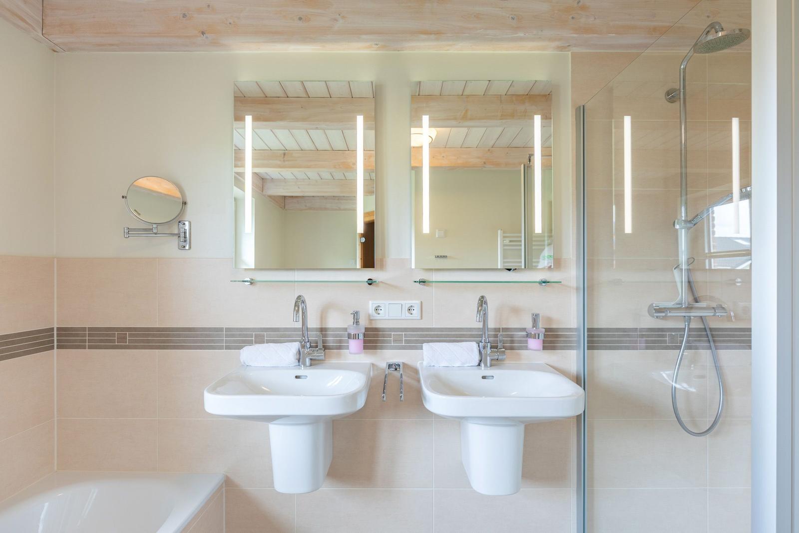 Badezimmer mit zwei Waschbecken, Dusche und Badewanne.