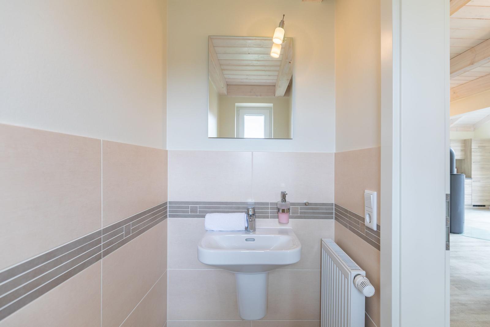 Badezimmer mit Waschbecken, Spiegel und Heizkörper