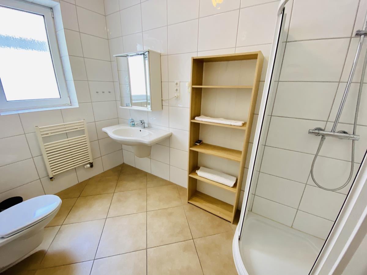 Badezimmer mit Dusche, Waschbecken und Toilette