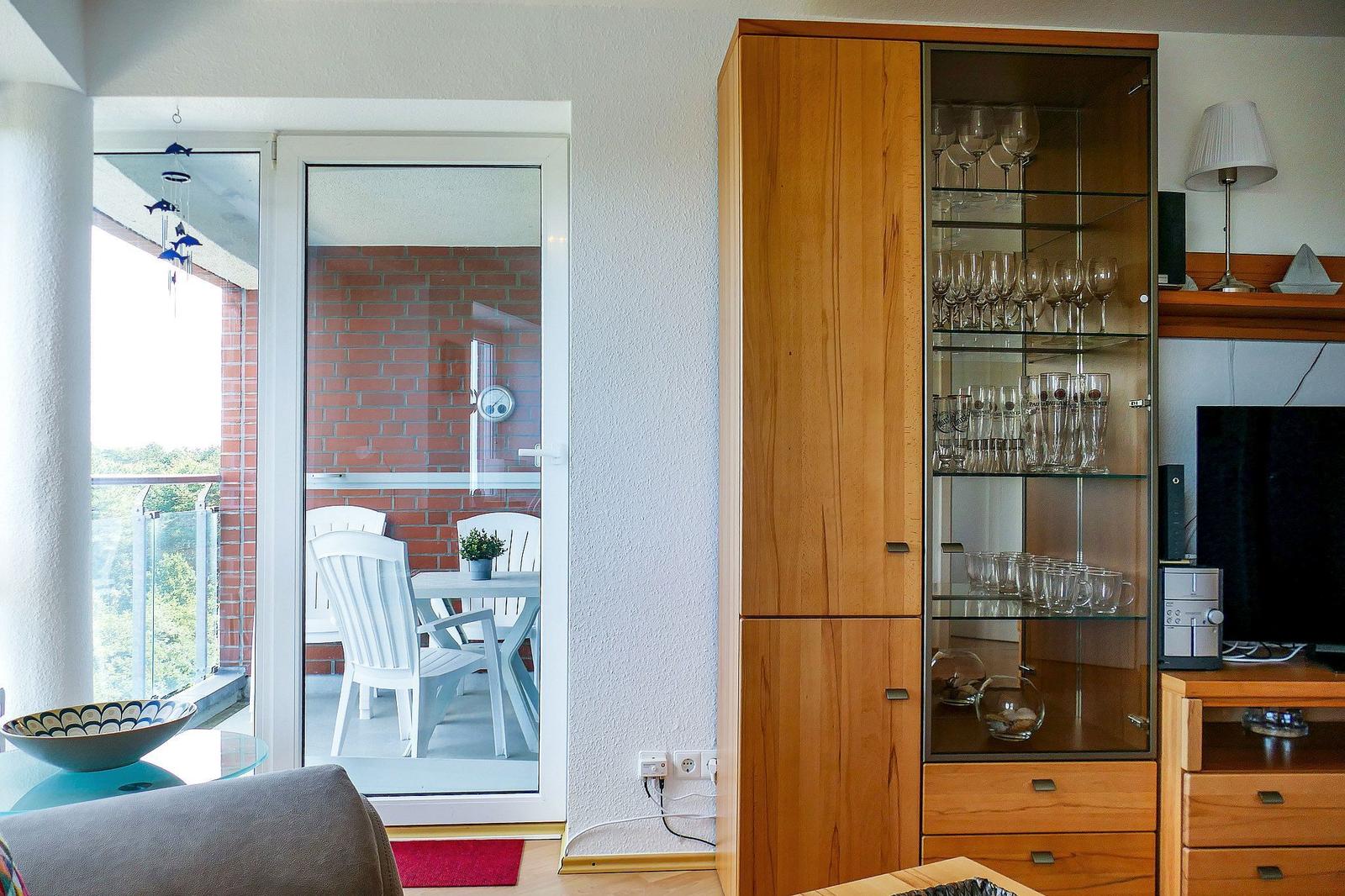 Wohnzimmer mit Balkon, Glasvitrine und Fernseher