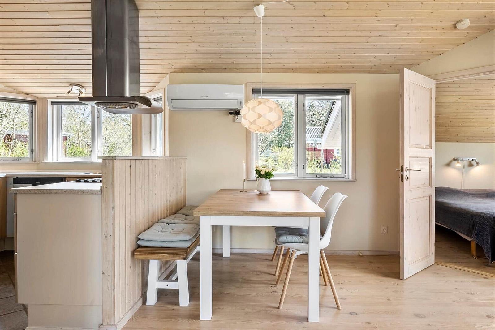 Küche mit Essbereich und Schlafzimmer im Hintergrund.