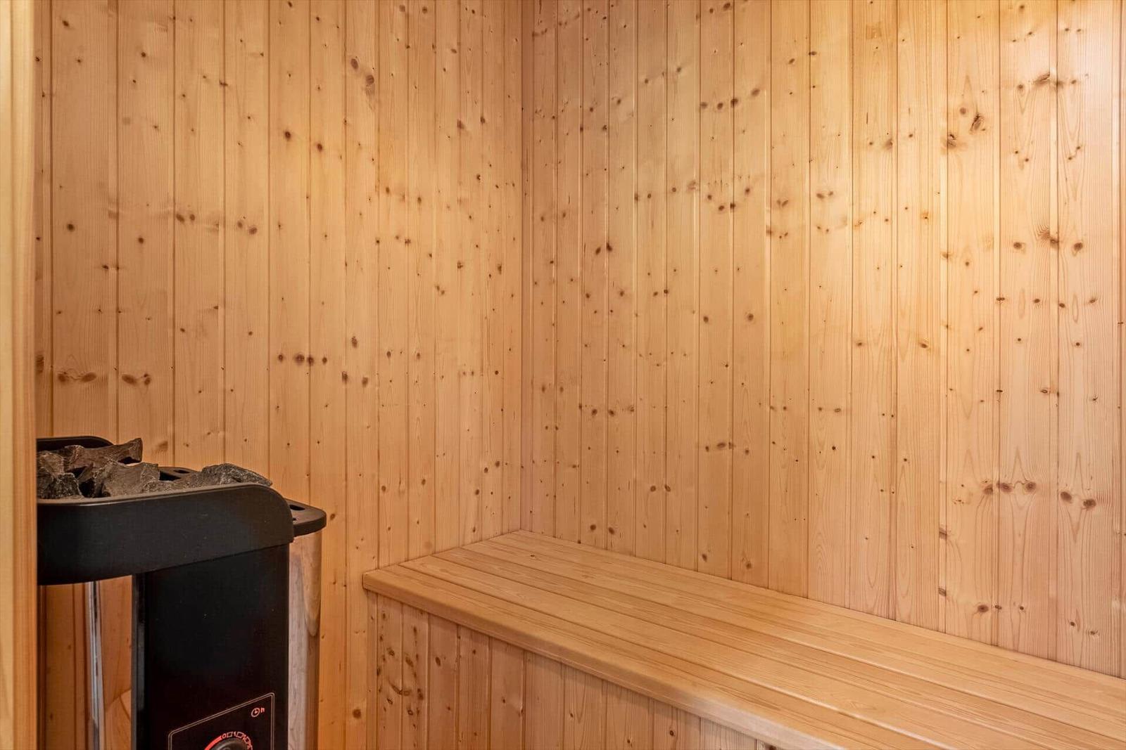 Sauna mit Holzwand und Sitzbank sowie Heizung.