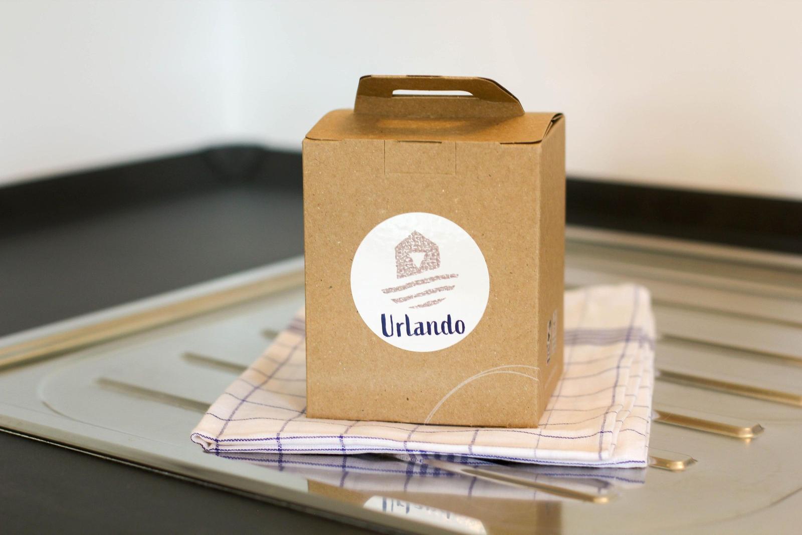 Karton mit Logo steht auf Küchenhandtuch.