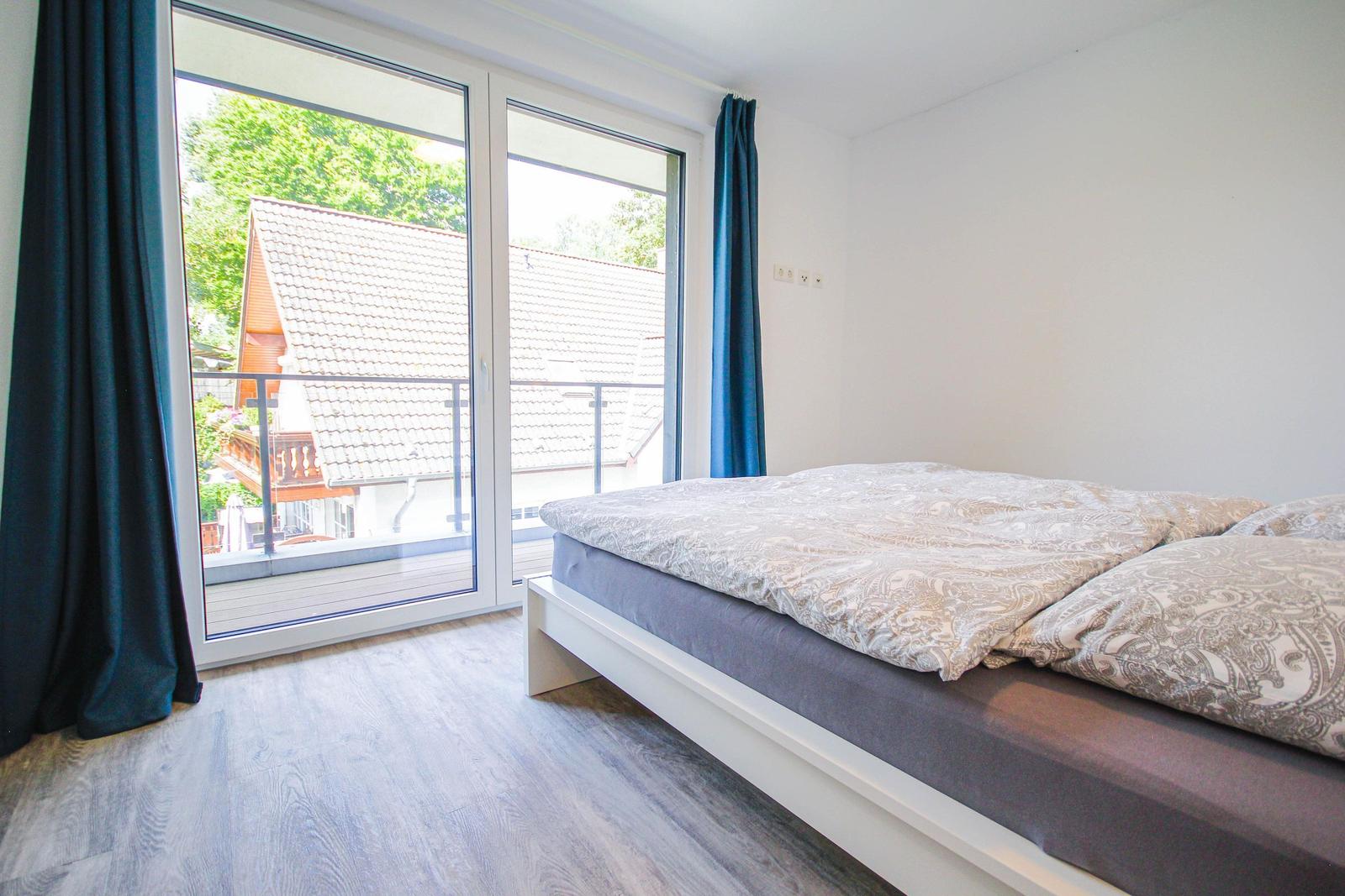 Schlafzimmer mit Bett und Balkonansicht