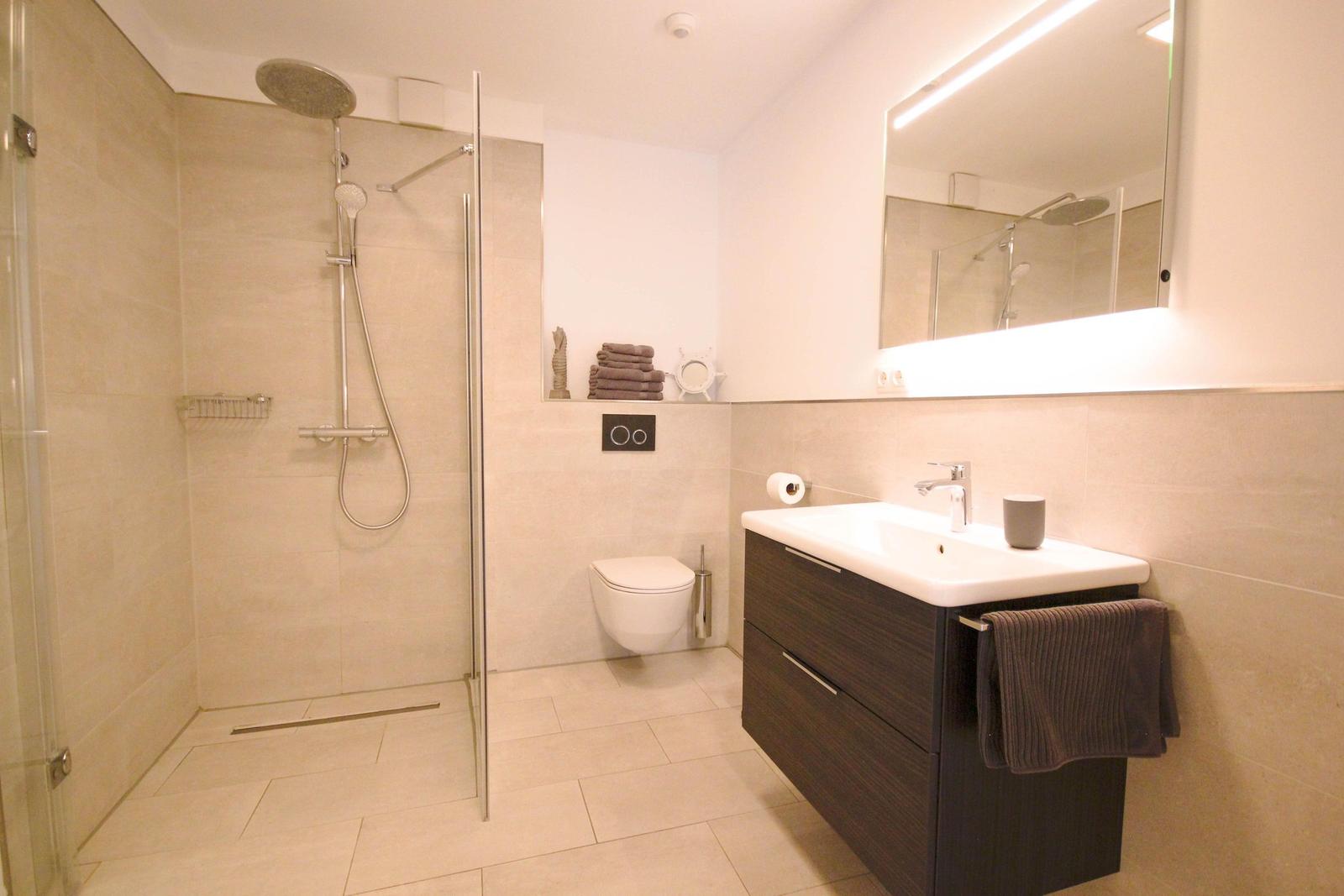 Moderne Badezimmer mit Dusche, Waschbecken und Toilette.