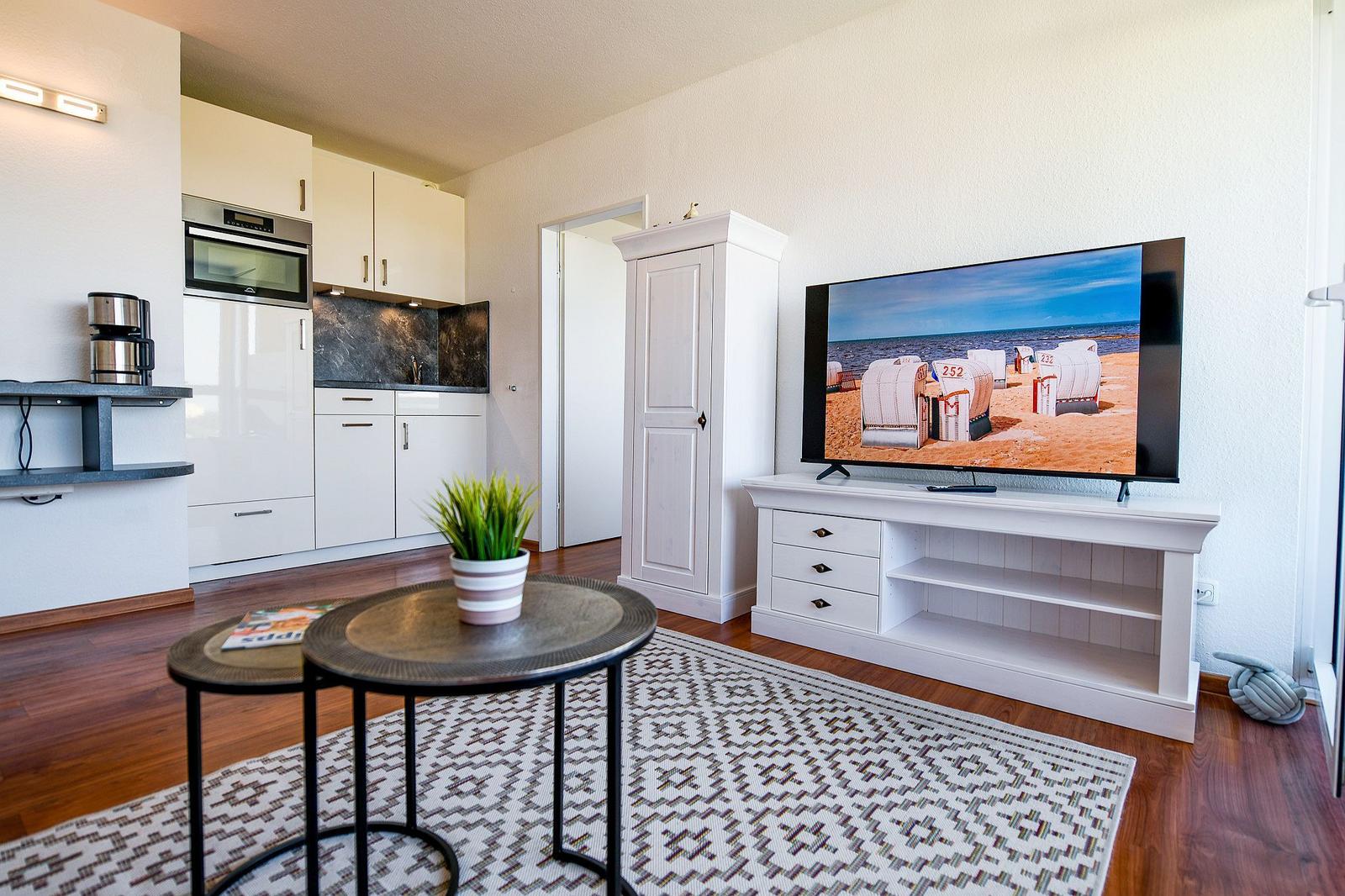 Wohnbereich mit Küche, TV und Holzboden