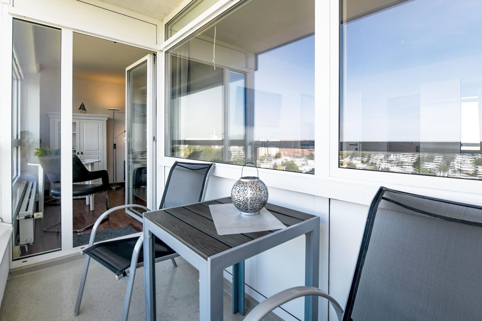 Balkon mit Tisch und Stühlen, Blick auf die Stadt.