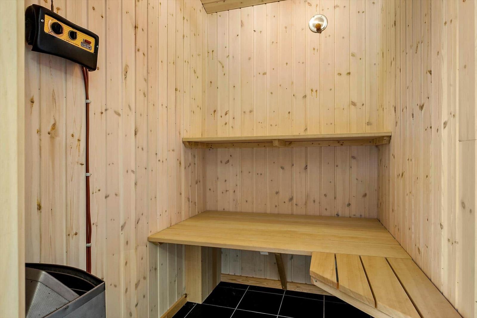 Sauna mit Holzwand, Sitzbank und Heizung.