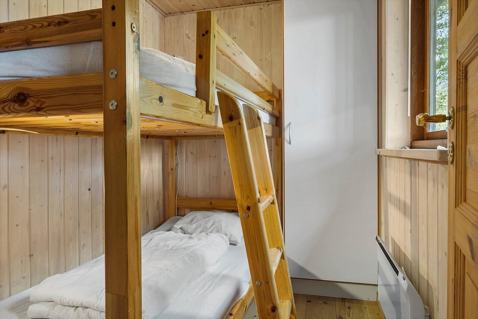 Zimmer mit Holzbett, Fenster und Tür