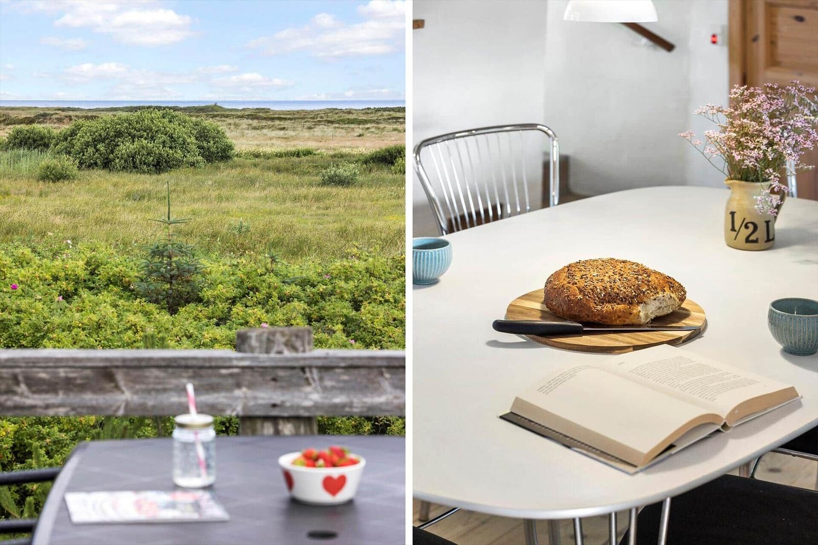 Terrasse mit Blick auf Grasland und Meer. Esszimmertisch mit Brot, Buch und Blumen.