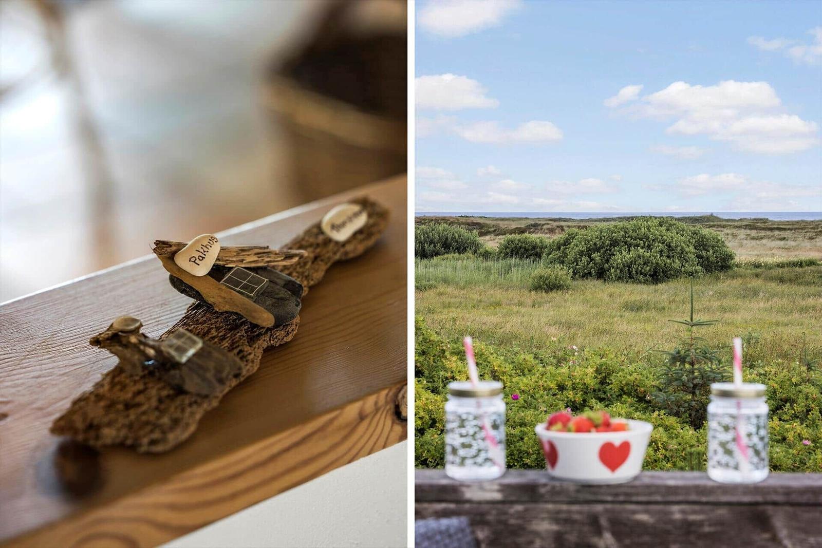 Holzdekoration auf Tisch. Blick auf Grasland und Meer mit Obstschale und Gläsern.