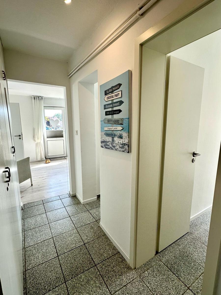 Flur mit Tür zu Schlafzimmer und Wandbild mit Strandmotiv