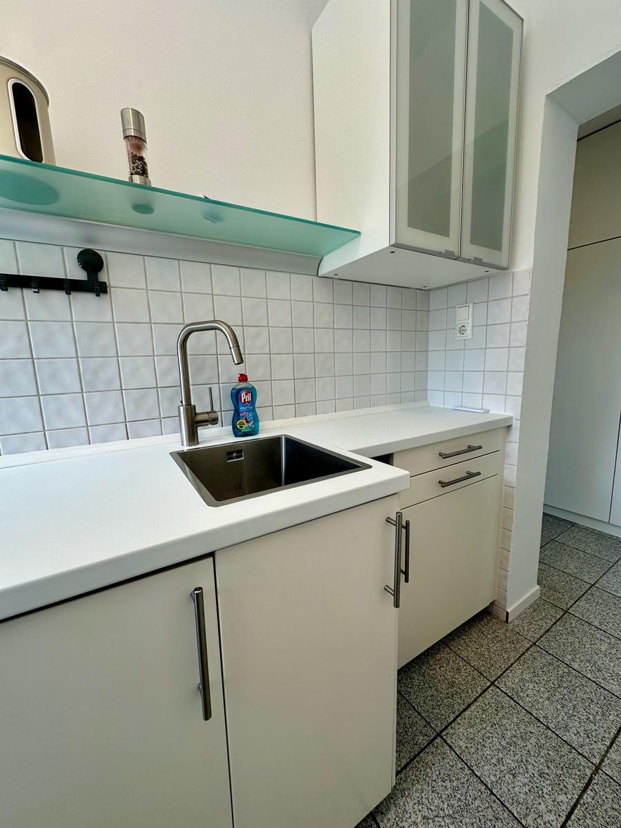 Küche mit Spüle, Arbeitsfläche und Schränken