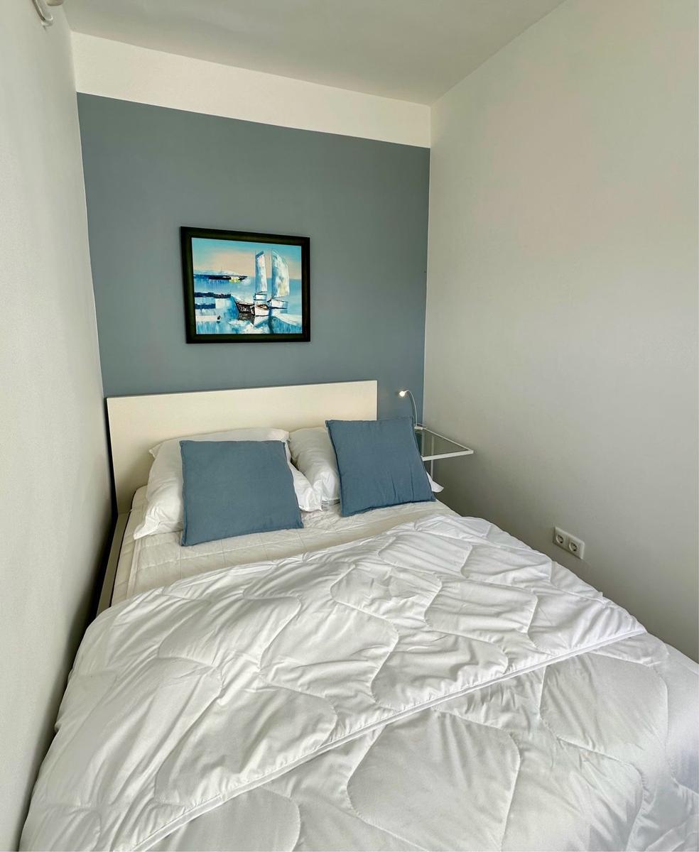 Schlafzimmer mit Bett, Kissen und Wandbild