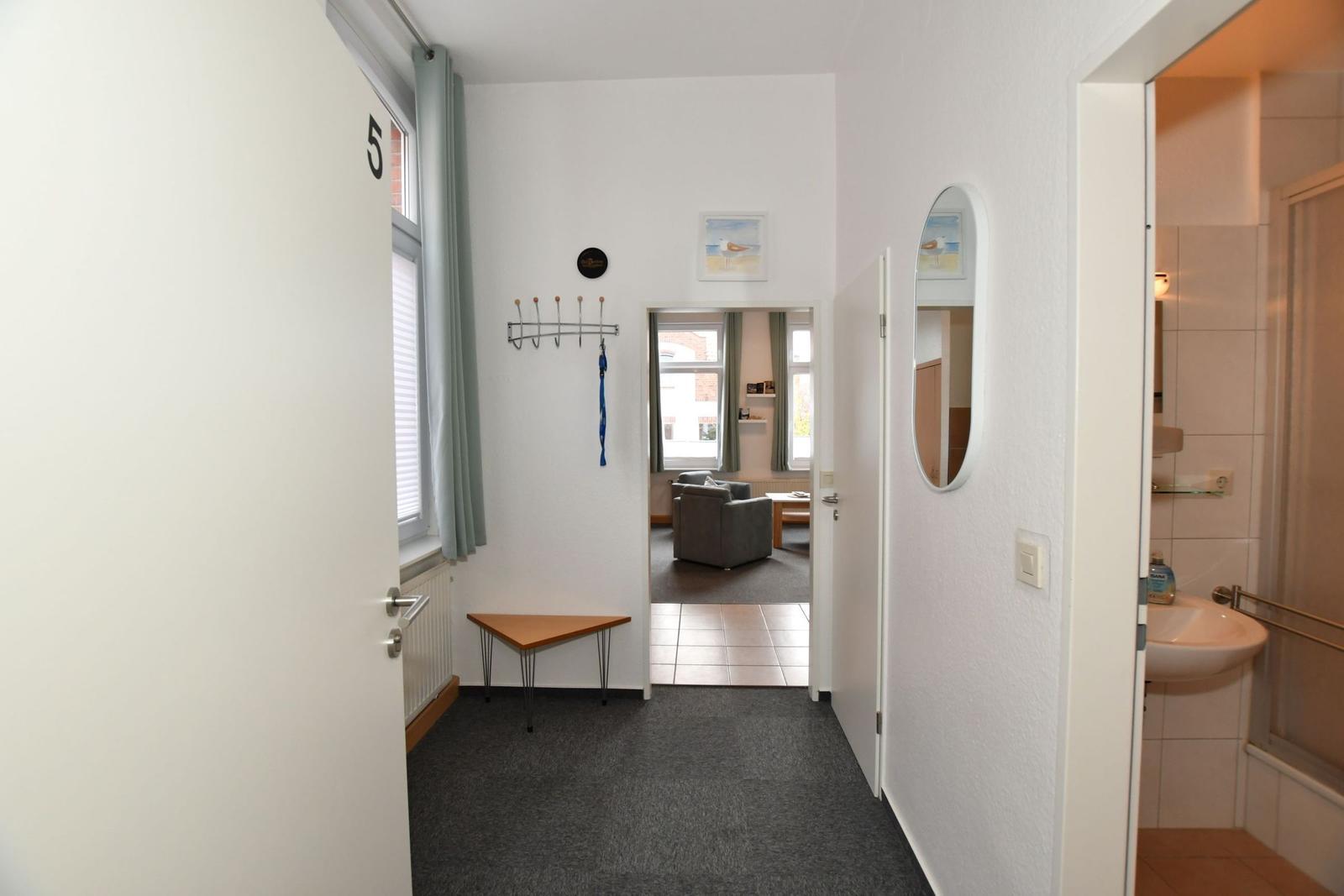 Eingangsbereich mit Flur, Bad und Blick in Wohnzimmer.