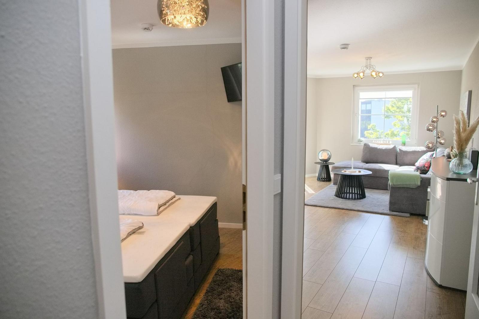 Schlafzimmer mit Bett und Wohnzimmer mit Sofa und Fenster.