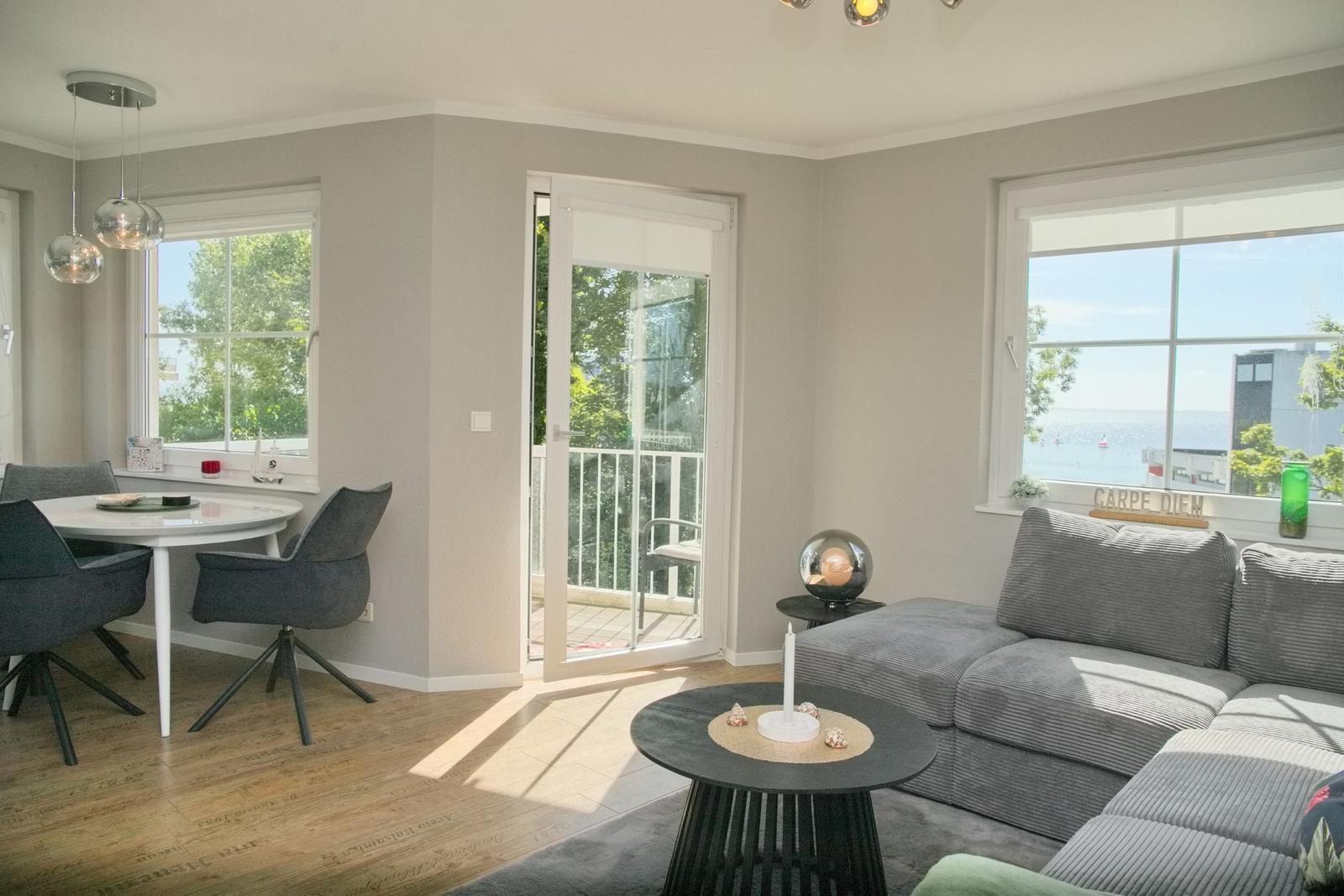 Wohn- und Essbereich mit Blick aufs Meer und Balkon.