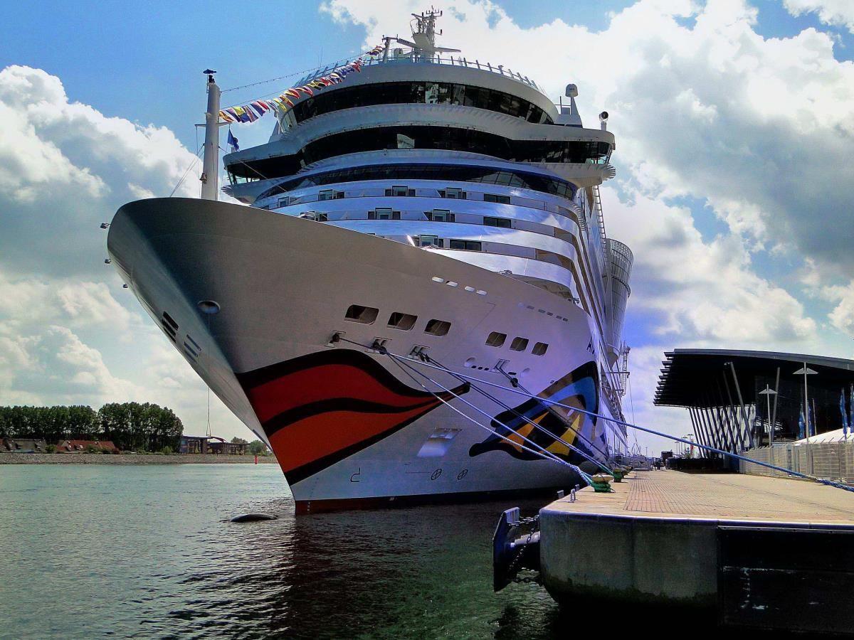 Großes Kreuzfahrtschiff am Hafen mit moderner Anlegestelle.